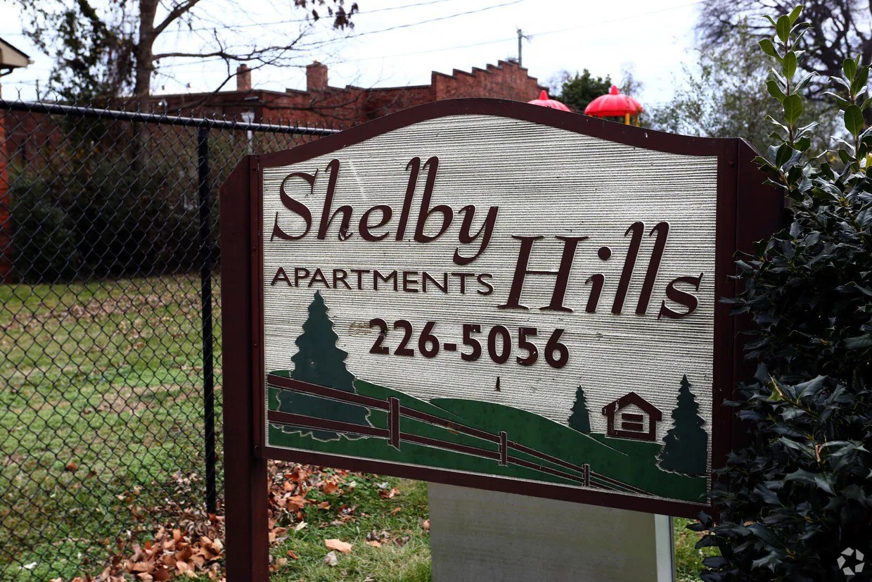 A sign for Shelby Hills Apartments with a phone number on it.